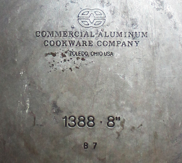 一個 1970 年代的 Calphalon 硬質陽極氧化鋁鍋的鍋底銘文，可以看到當時的正式公司名稱仍是 Commercial，logo 的圖案和今天的 Calphalon 基本一致